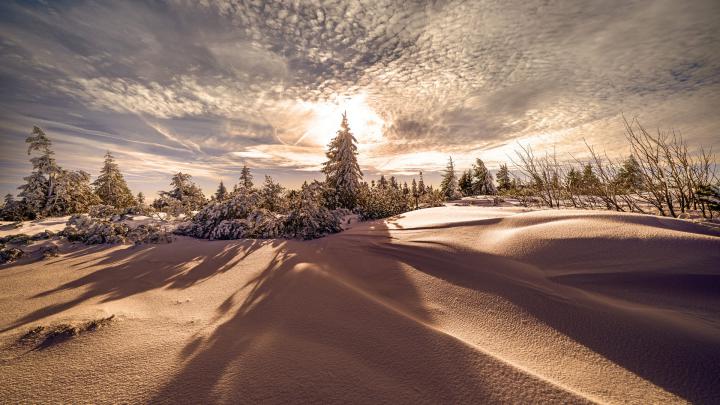 Snow Covered Hills With Trees In Background Of Sky With Clouds During 