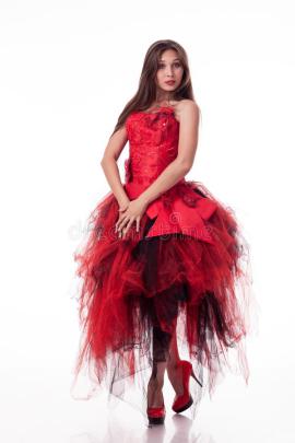 Beautiful Girl In Red Dress Posing On Camera On White Background. Stock 